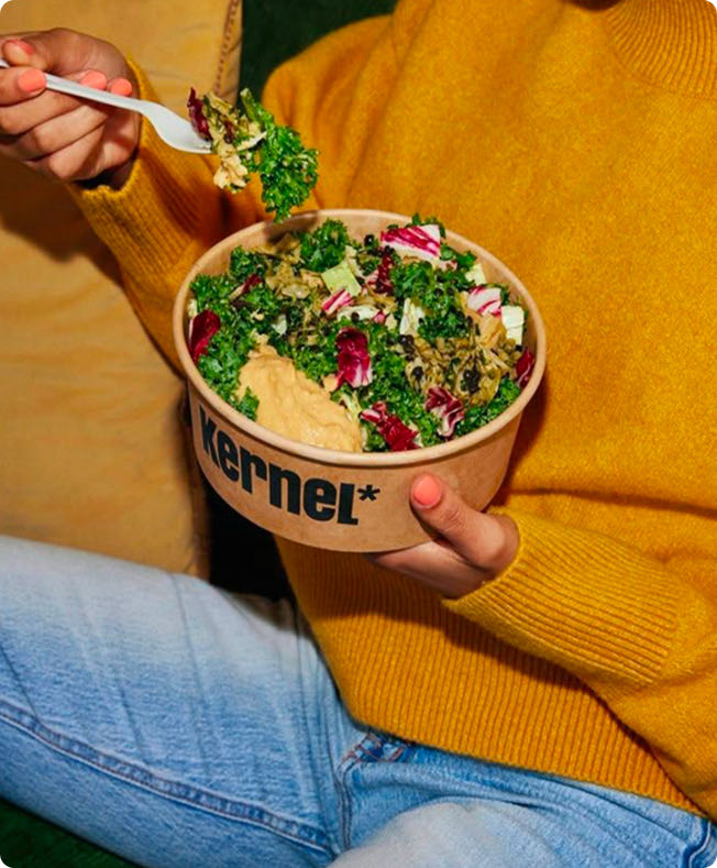 Femme qui mange une salade avec de l'houmous